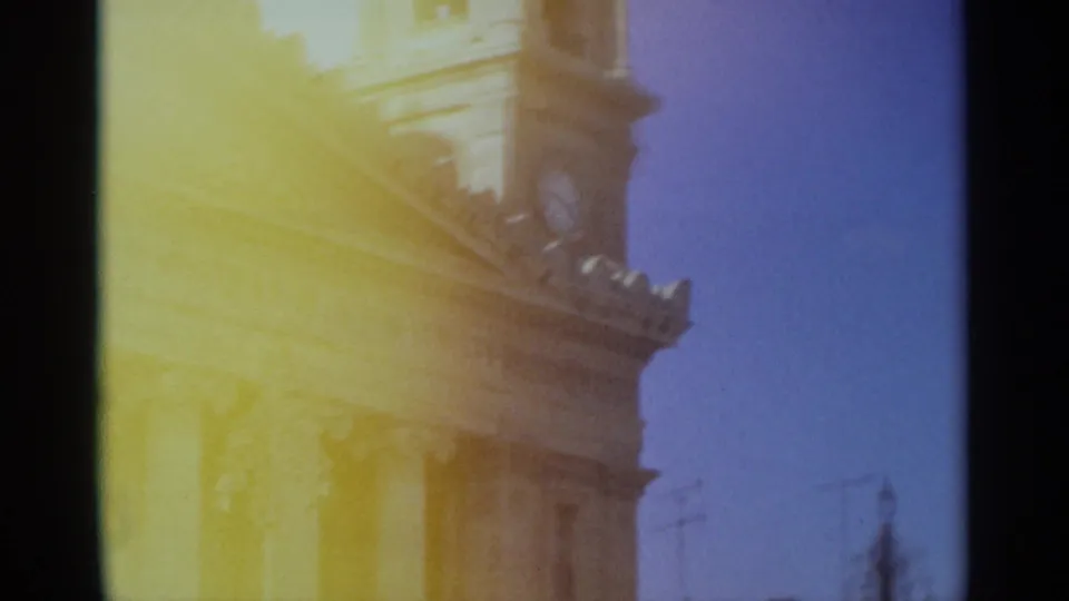 1965 Tangier frame with the building's upper facade and clock tower partly obscured by strong yellow 8mm light flare.