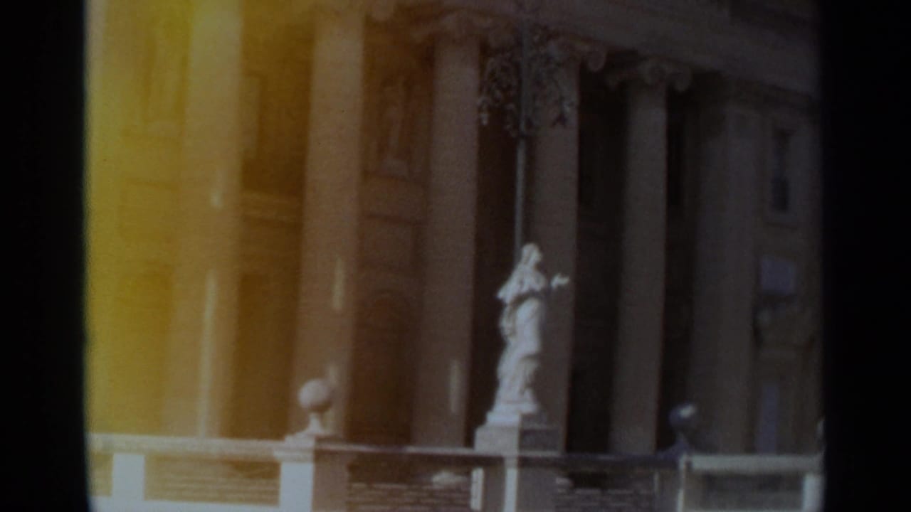 1965 Tangier home-movie view of a columned building entrance with a white statue on a pedestal in front.
