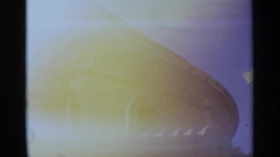 1960s 8mm travel frame showing a sun-faded domed church roof with arched detail and heavy yellow-blue color shift.