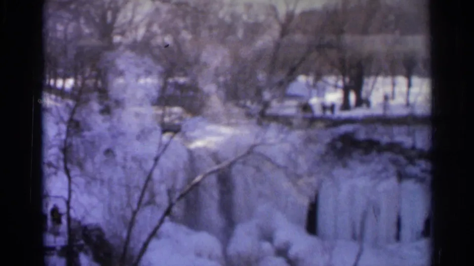 1966 Hamel, Minnesota winter scene with icy falls, snow-covered ground, bare trees, and indistinct people on the far side.
