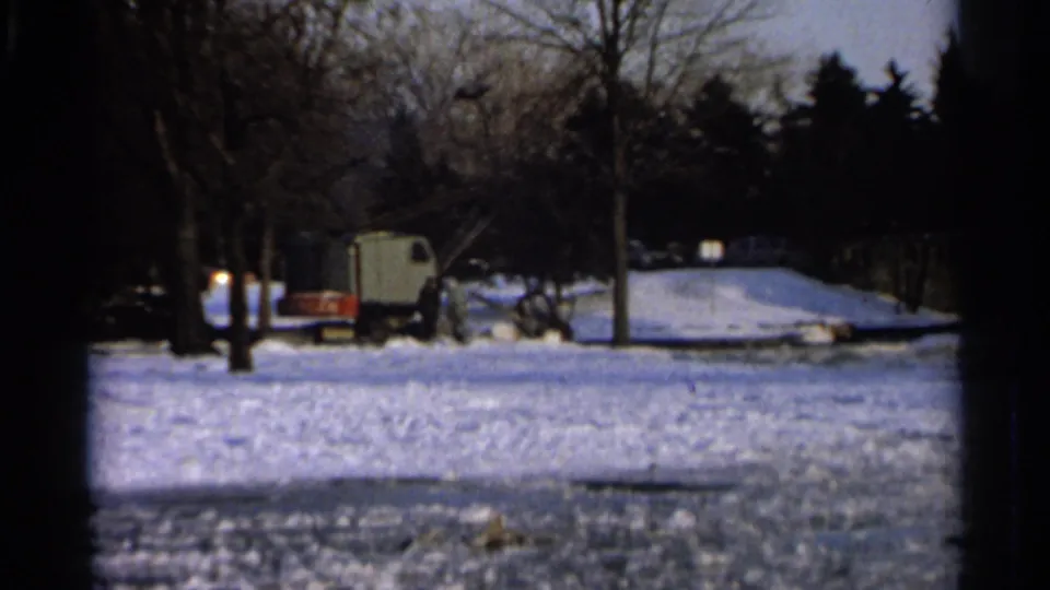 1966 Hamel, Minnesota frame with snow-covered ground, bare trees, and distant winter maintenance equipment.