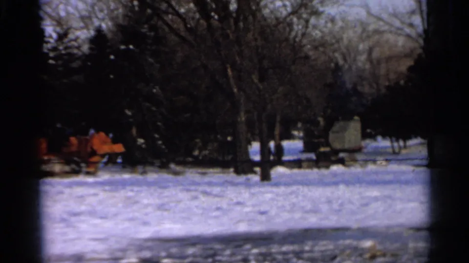 1966 Hamel, Minnesota frame with orange snow-moving machinery, a pale equipment unit, trees, and snow cover.