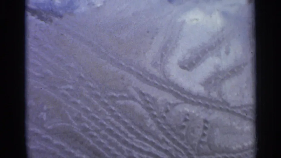 1966 Hamel, Minnesota 8mm frame showing parallel snowmobile track grooves and compacted snow in a close outdoor view.