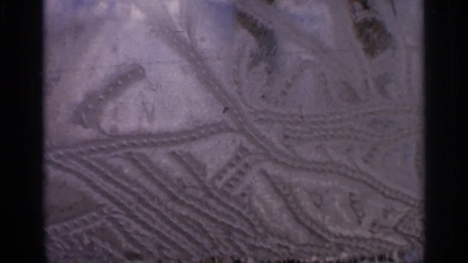 Final 8mm frame of snowmobile tracks in Hamel, Minnesota snow, with visible grain and purple-blue aging.