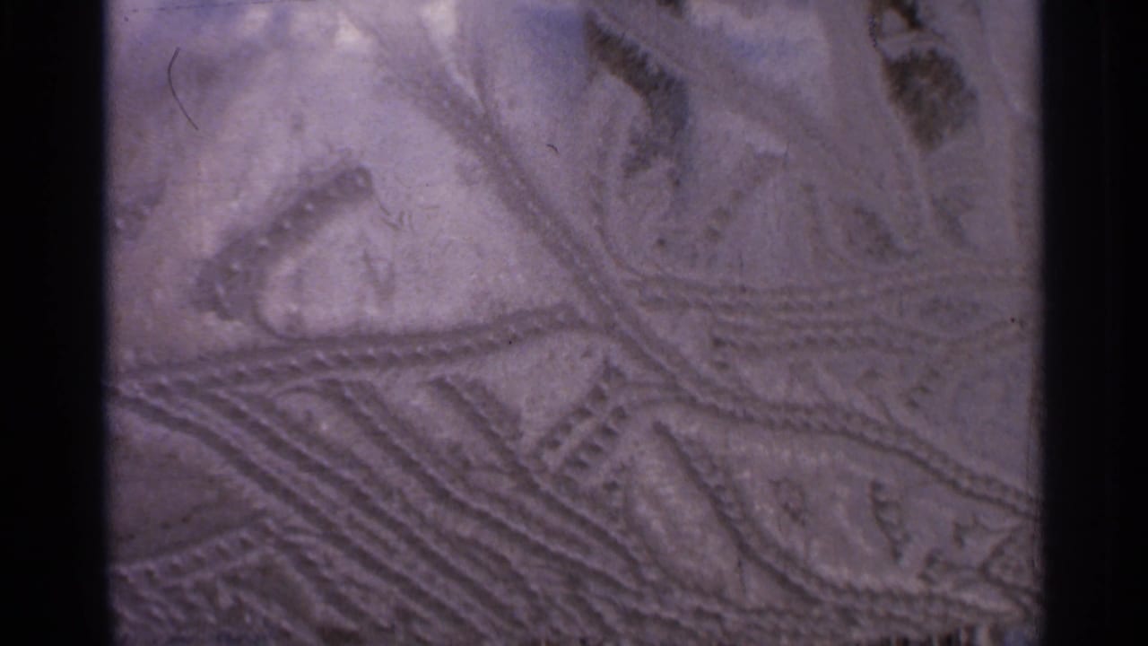 1966 Hamel, Minnesota 8mm close-up showing shallow carved grooves and branching marks across a textured surface.