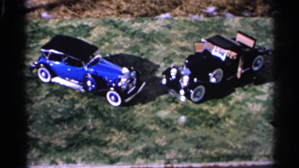 1966 Hamel, Minnesota frame with two stationary classic cars, chrome details, whitewall tires, and dark film borders.