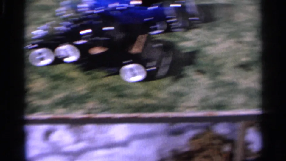 The black and blue remote-controlled toy cars streak across the grass near the end of the short 1966 Hamel clip.