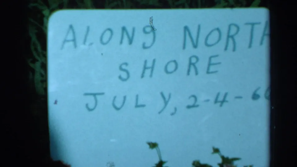Handwritten title card in the 1966 home-movie clip, with visible text reading “ALONG NORTH SHORE” and partial July date notation.