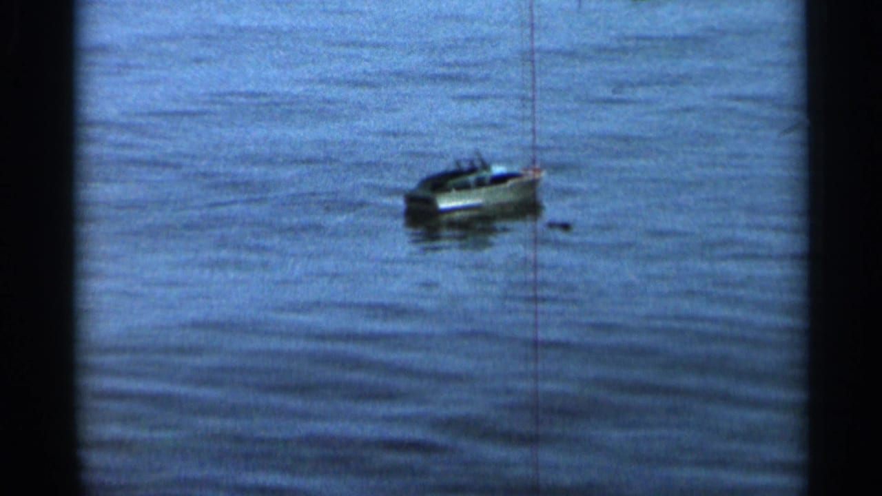 A small toy sailboat drifts on calm lake water in 1966 home-movie footage from the Hamel, Minnesota metadata.