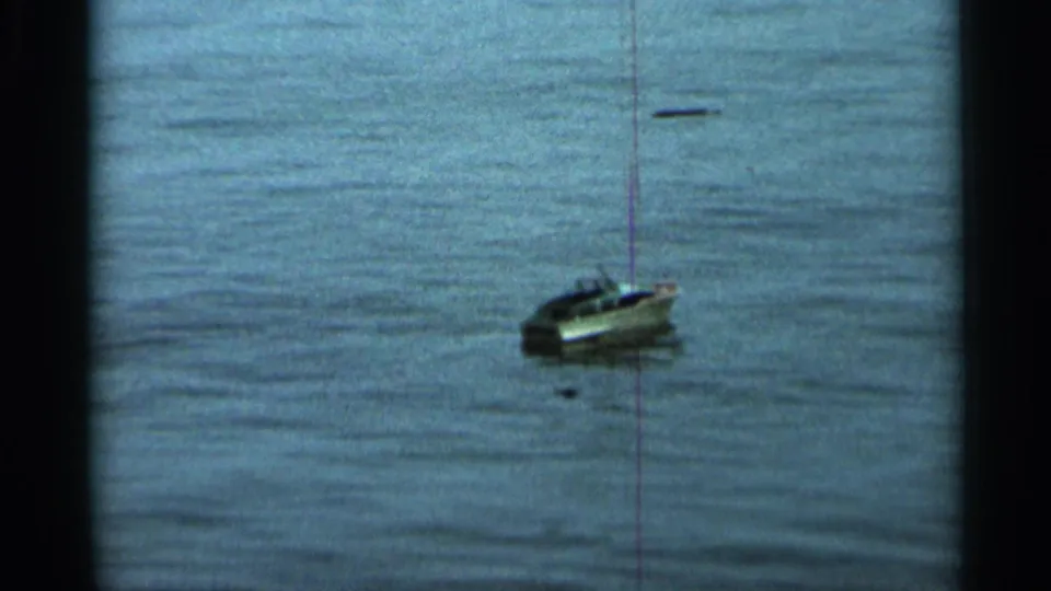 The toy sailboat appears on open lake water, framed by visible 8mm contact-sheet borders and a vertical film line.