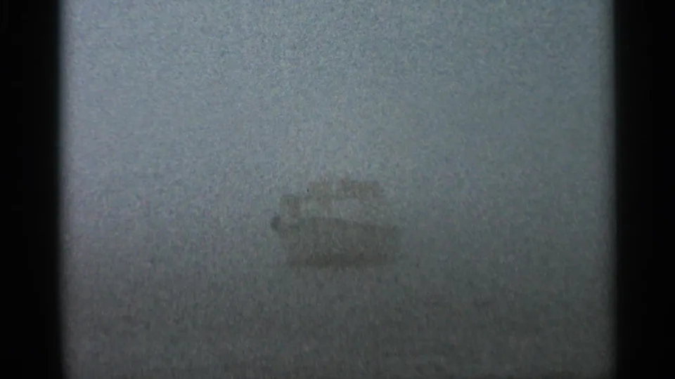 1966 Hamel, Minnesota 8mm frame with a pale boat silhouette partly hidden by dense fog over calm water.