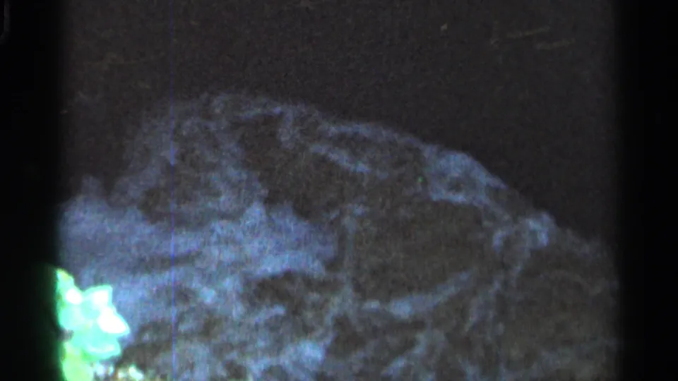 1966 Hamel, Minnesota 8mm frame with pale water flowing across dark rocks in a tight natural stream view.