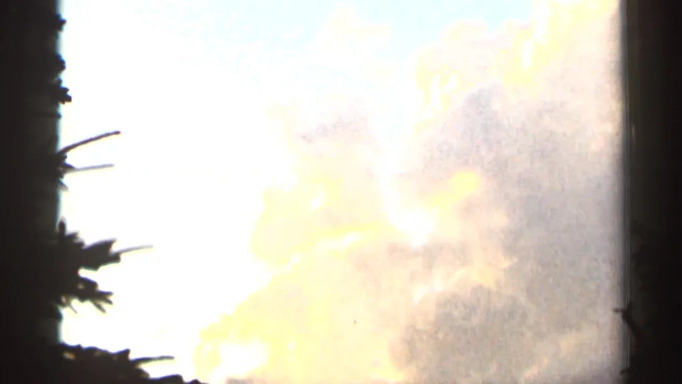 A bright overexposed sky with pale clouds appears in the 1966 8mm footage, framed by dark gate edges and soft film grain.