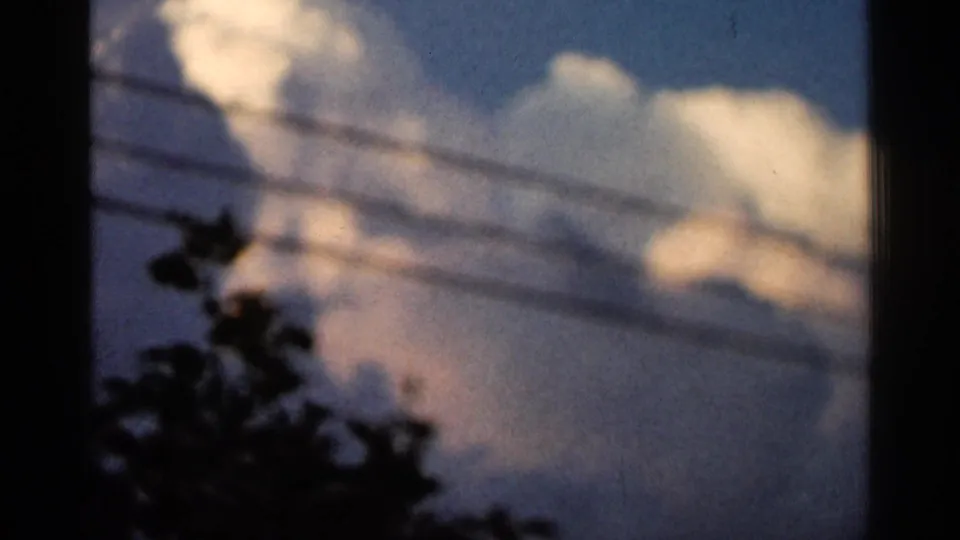 1966 Hamel, Minnesota 8mm frame showing a blue sunset sky with pale clouds, utility lines, and dark tree silhouettes.
