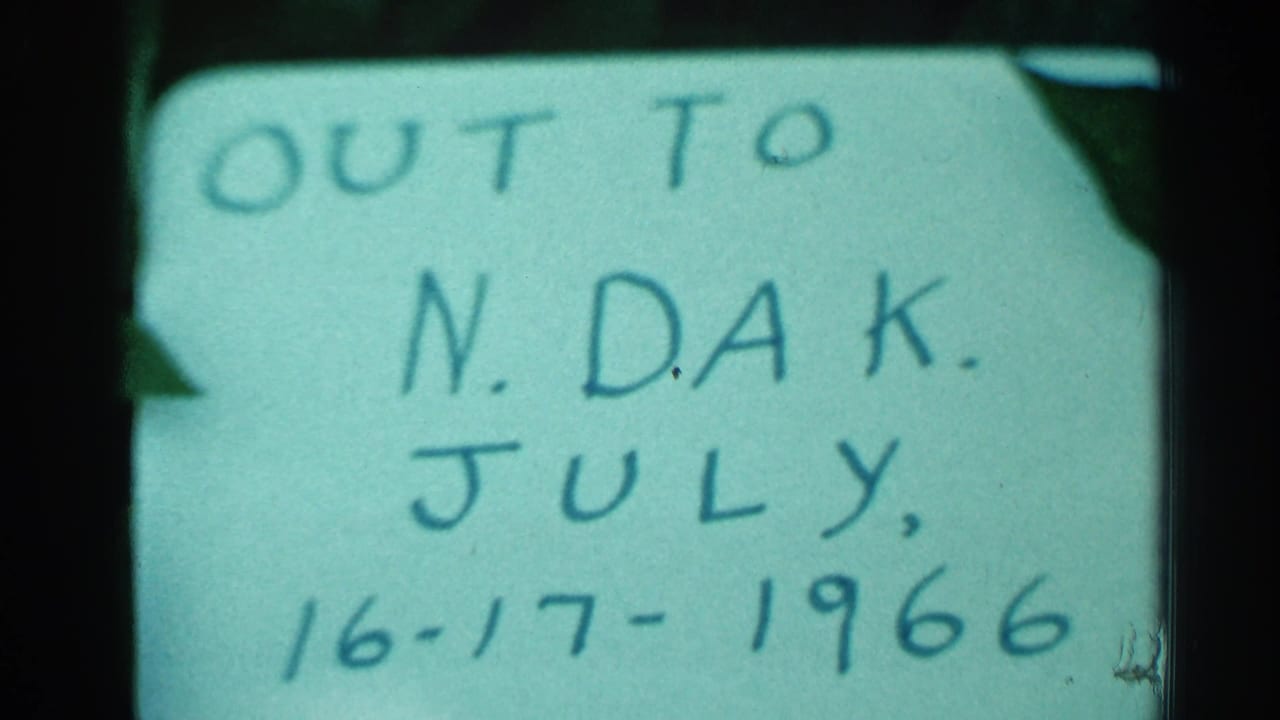 1966 8mm frame from Hamel, Minnesota showing a handwritten North Dakota July travel note on a pale card.