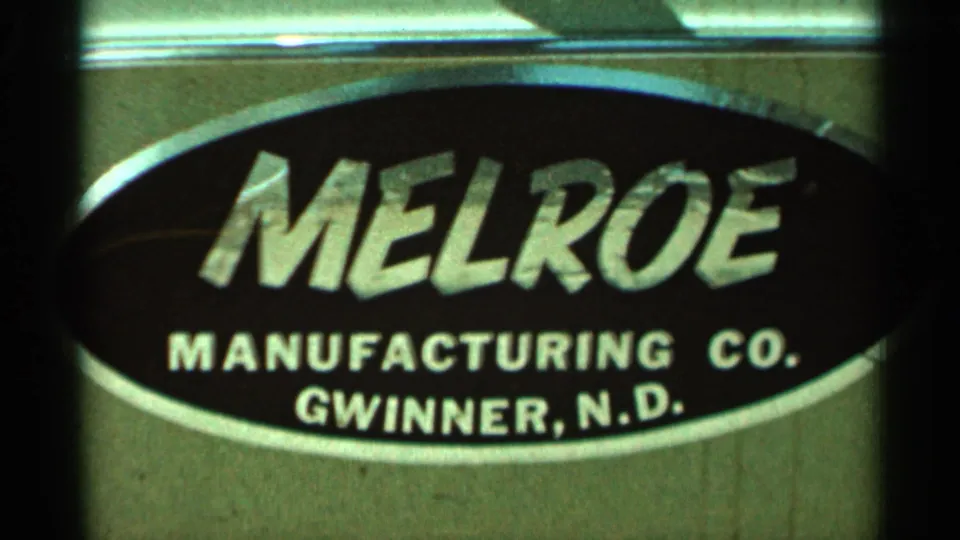 Close 8mm frame of the Melroe Manufacturing Co. sign, including Gwinner, N.D. text, from the Hamel, Minnesota clip.