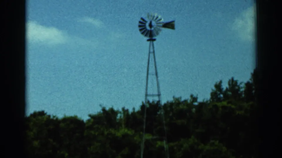 1966 Hamel, Minnesota 8mm frame with the windmill slightly right of center above dark trees and open sky.