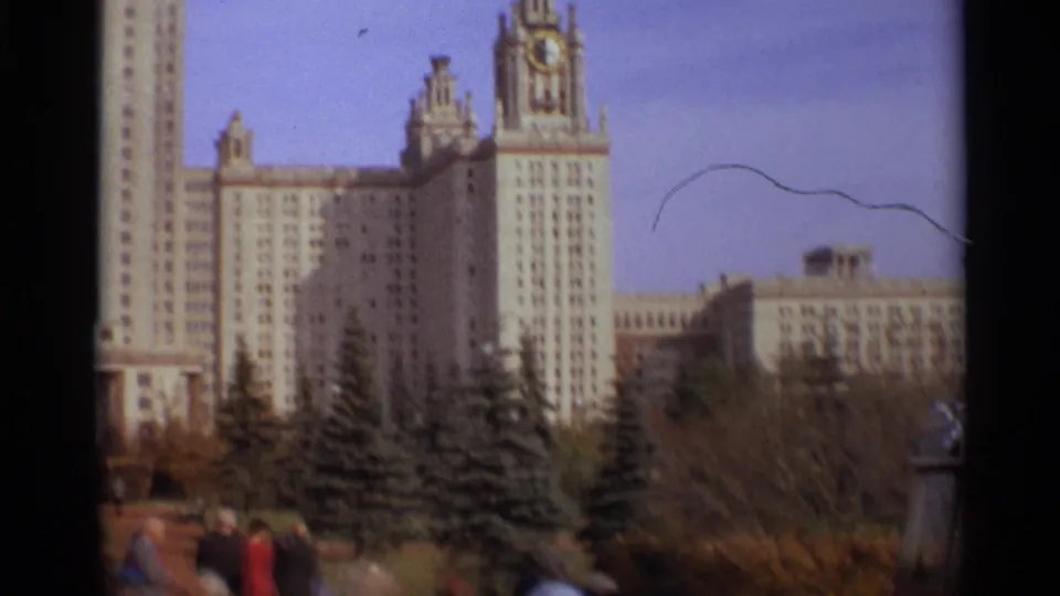 1966 Moscow frame with Moscow State University, campus plantings, and small pedestrians near the lower edge of the shot.