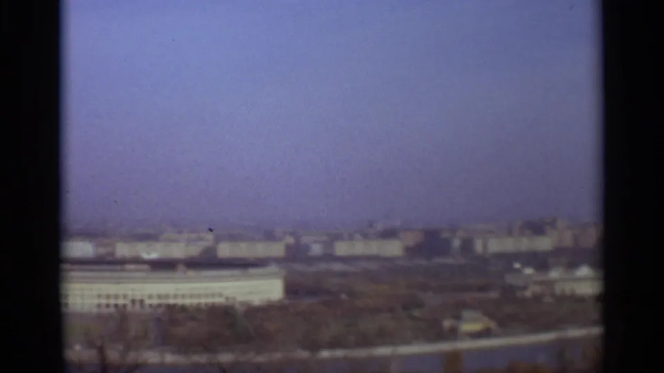 1966 Moscow frame with a broad low building, distant urban blocks, haze, and visible 8mm frame edges.