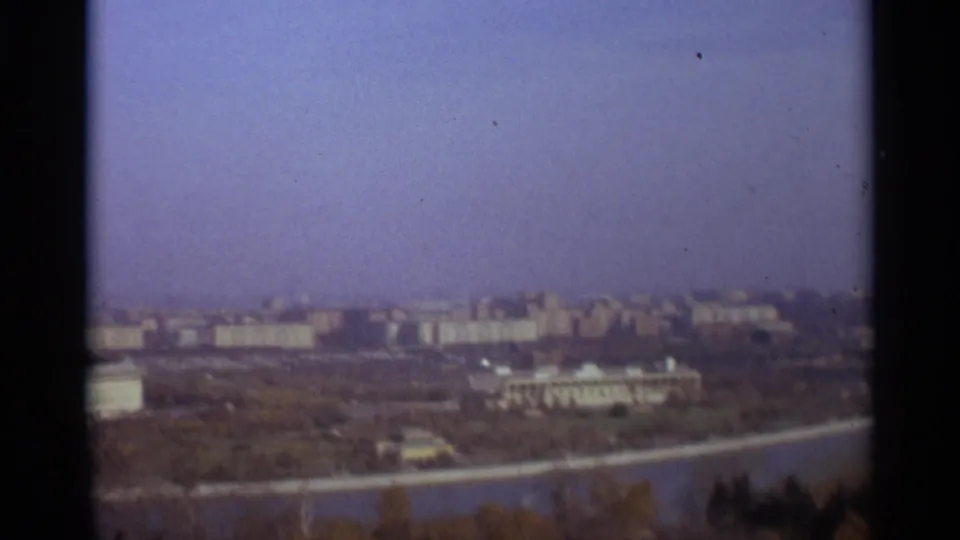 1966 Moscow home-movie view looking over riverside buildings, a bridge or road, trees, and haze.