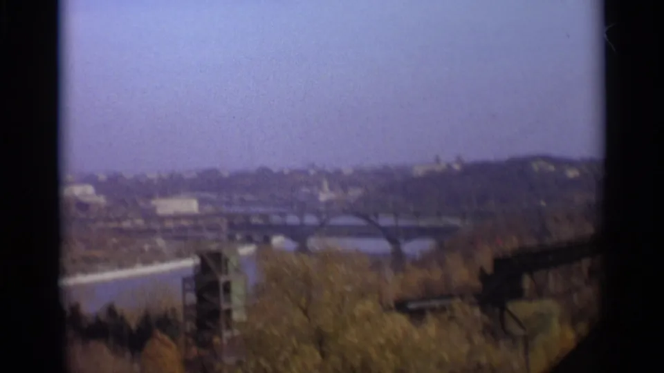 1966 Moscow 8mm frame with a soft skyline, river bend, arched bridges, and trees in the foreground.