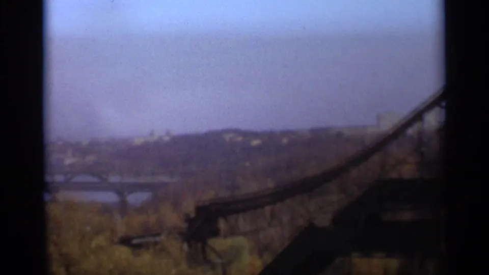1966 Moscow home-movie view with a bridge span in the foreground, autumn trees, river, and distant urban landscape.