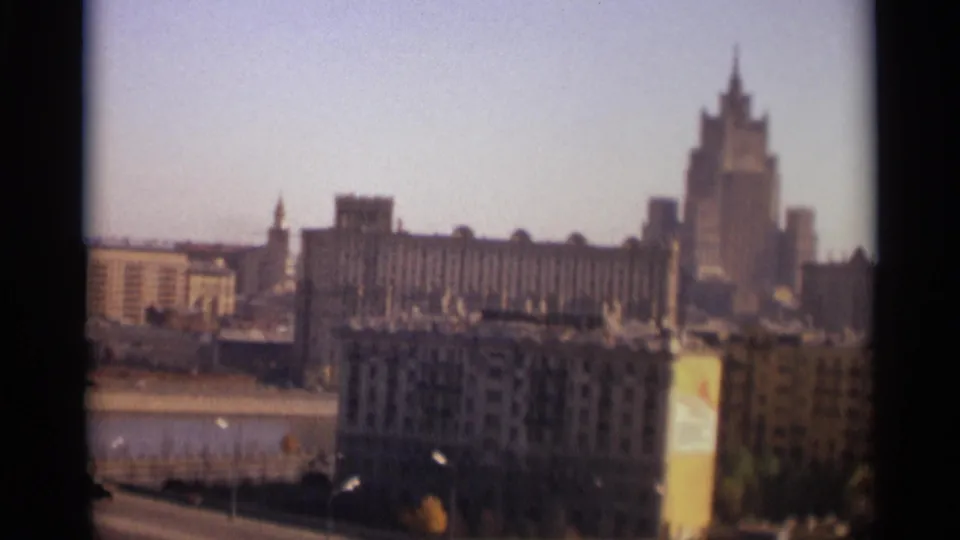 1966 Moscow urban panorama with soft focus, showing a river, traffic on the lower road, and monumental buildings across the skyline.
