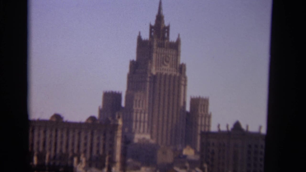 1966 Moscow home-movie frame showing a tall Stalinist-style skyscraper with an ornate central spire.