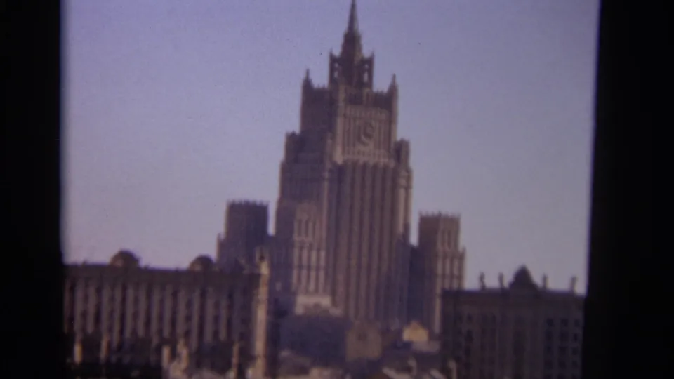 1966 Moscow home-movie frame showing a tall Stalinist-style skyscraper with an ornate central spire.