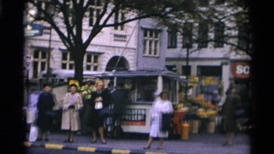 1966 Moscow street view showing women in mid-century coats by a kiosk, flower buckets, signage, and a pale urban facade.
