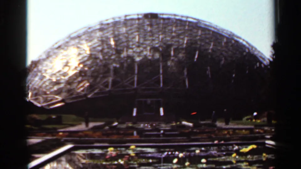 Handheld 8mm frame from Saint Louis in 1966 showing the dome structure, shaded entrance area, and water feature.