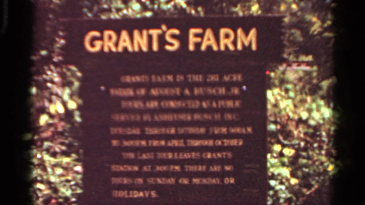 Grant's Farm sign surrounded by foliage, partially soft and warm-toned.