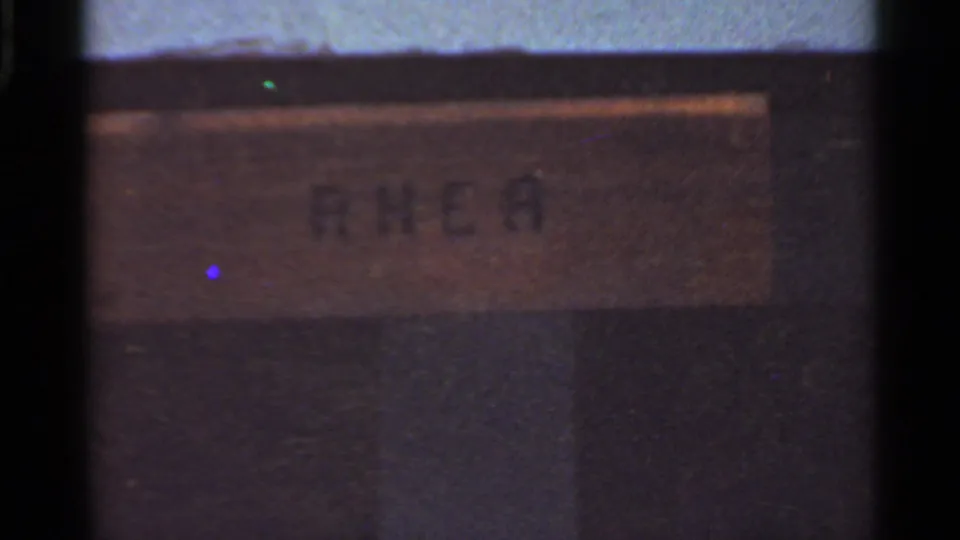 Faded 1966 8mm frame from Saint Louis showing a blurred enclosure sign or placard within heavy film borders.