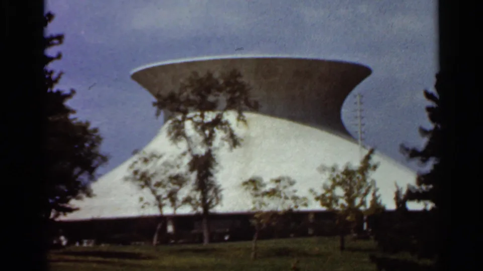 1966 St. Louis exterior view of the white modernist structure, its broad roofline partly obscured by trees.