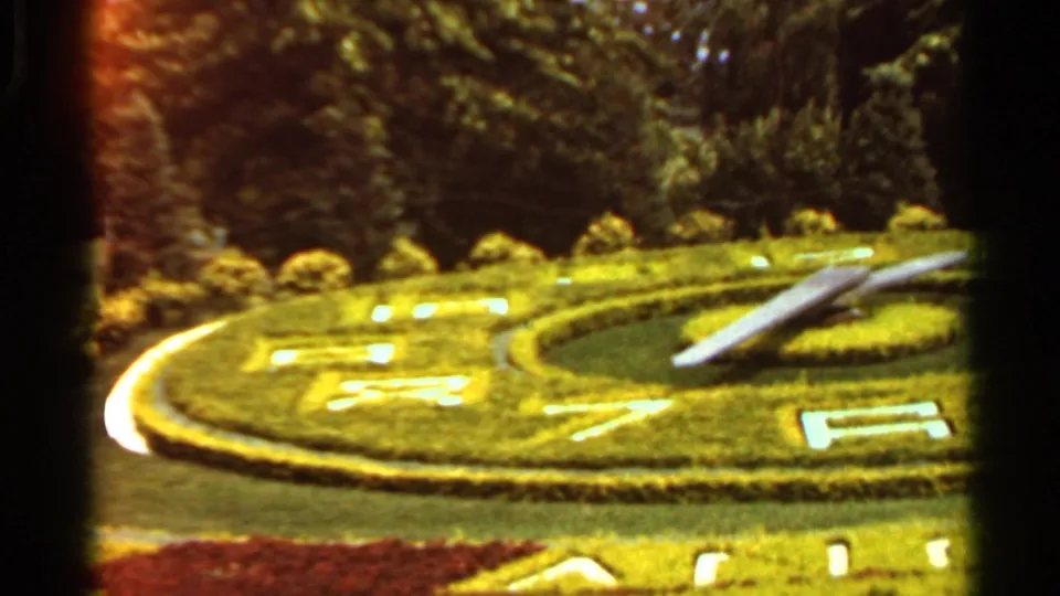1966 Saint Louis garden view showing a circular topiary clock, clipped hedges, flower beds, and surrounding trees.