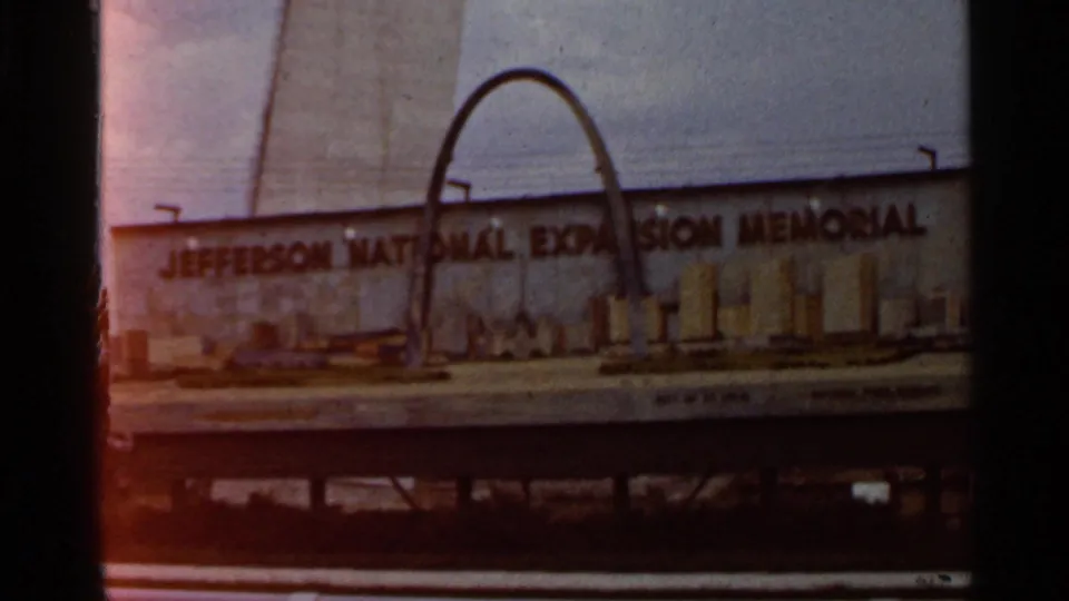 Saint Louis frame showing the Jefferson National Expansion Memorial sign, with the Gateway Arch rising behind the sign.