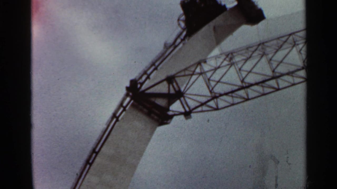 Low-angle view of steel lattice scaffolding against a cloudy sky.