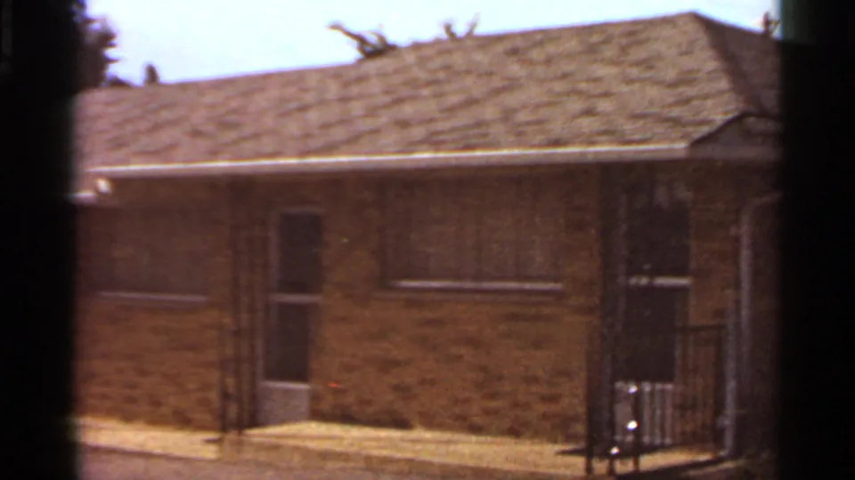 The final frame centers the brick motel exterior in Saint Louis, with doorways, posts, roofline, and a dark gate-like element at the edge.