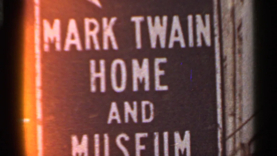 1966 Missouri frame showing the Mark Twain Home and Museum sign, with orange edge flare and soft 8mm focus.