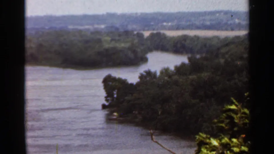 1966 Saint Louis-area 8mm frame showing a wide river bend and wooded shoreline from a high vantage point.
