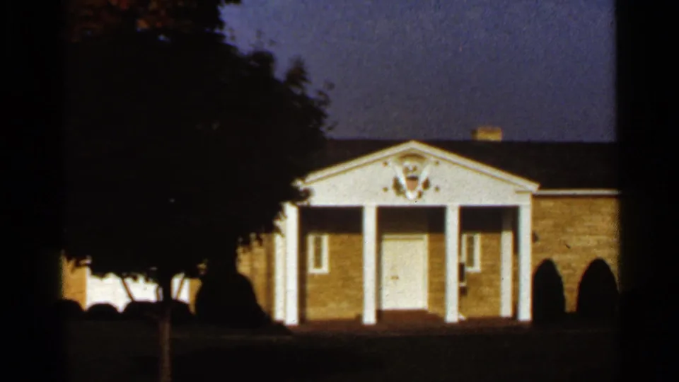 1966 St. Louis frame with a large foreground tree partly obscuring a brick building with white portico columns and a central entrance.