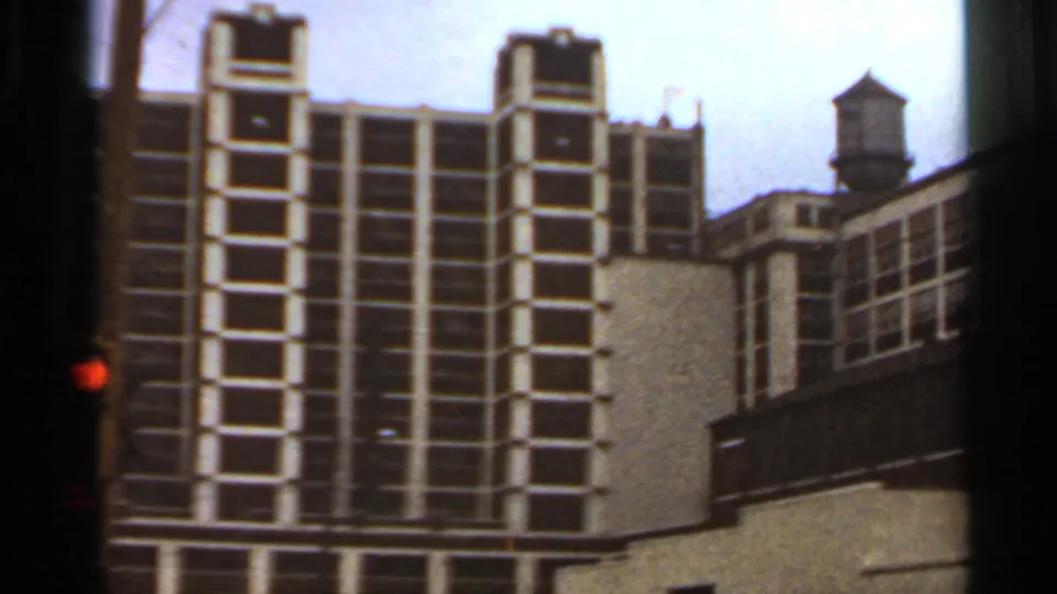 1966 Saint Louis building corner with repeated window bays, adjacent roofline, and a rooftop water tower visible.