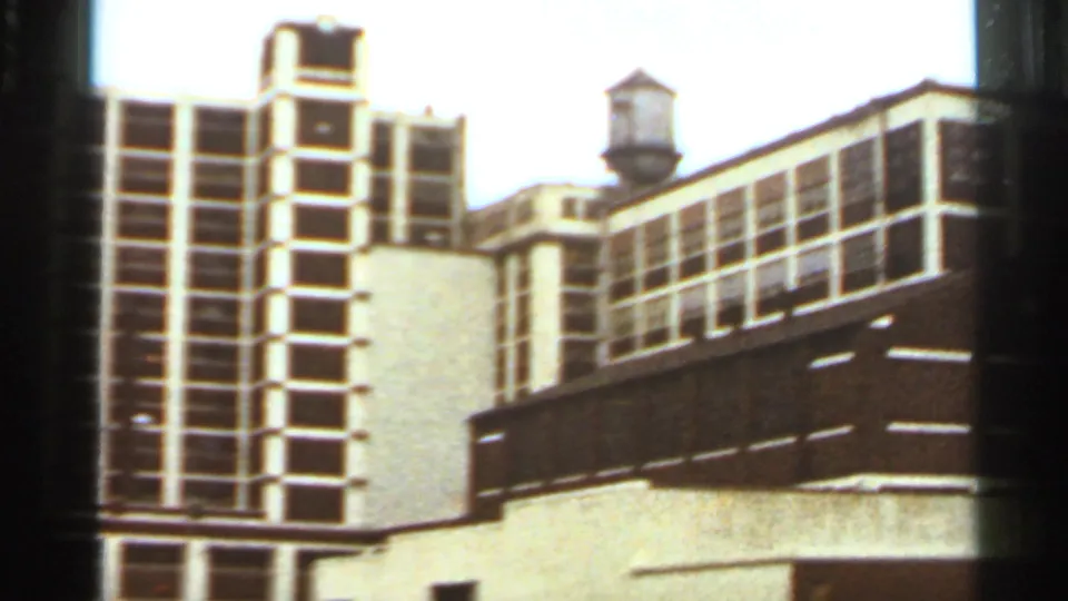 Saint Louis urban building view with a gridded facade, lower roofline, and rooftop water tower in the background.