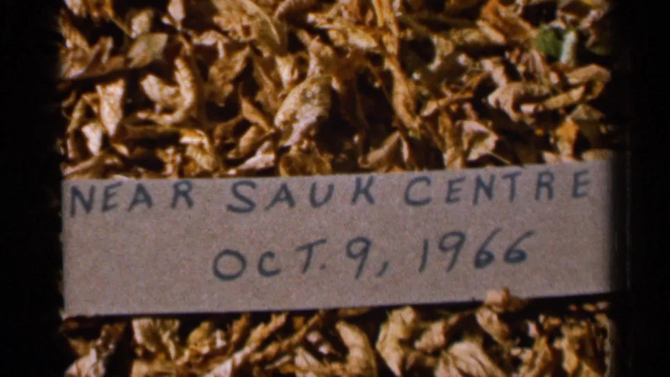 Close 8mm view of the handwritten “NEAR SAUK CENTRE” label with the October 9, 1966 date over fallen leaves.