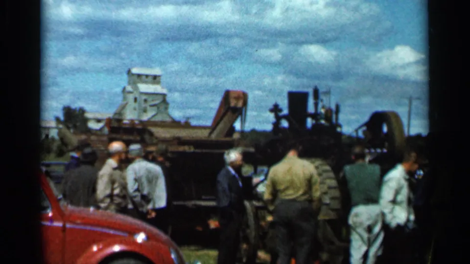 Wauseon, Ohio rail scene with onlookers facing equipment and a grain elevator visible across the tracks.