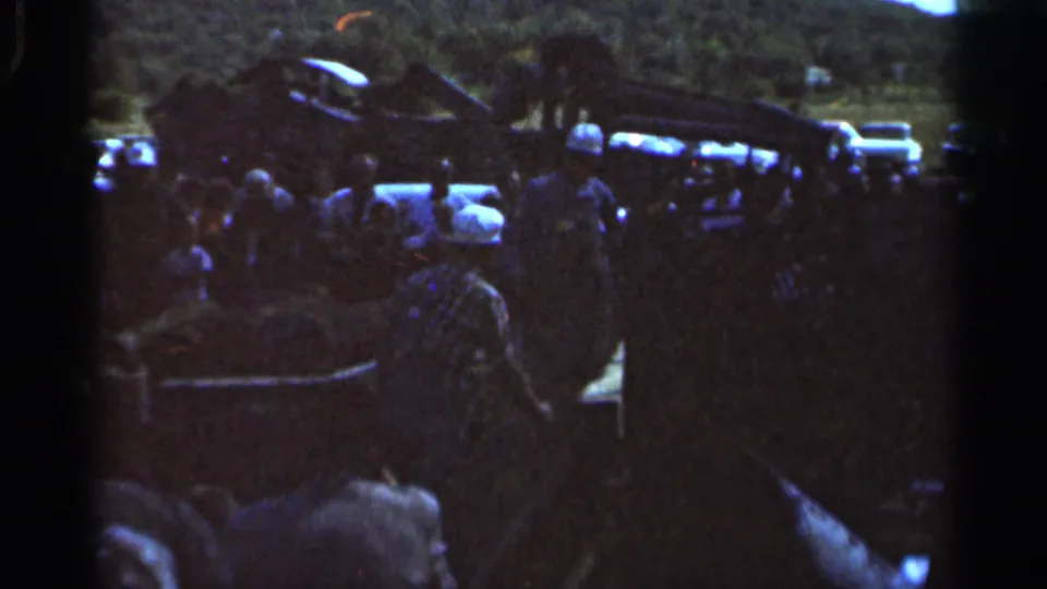 The final frame shows adults gathered around machinery in a grassy Wauseon field, with parked cars and a wooded backdrop.