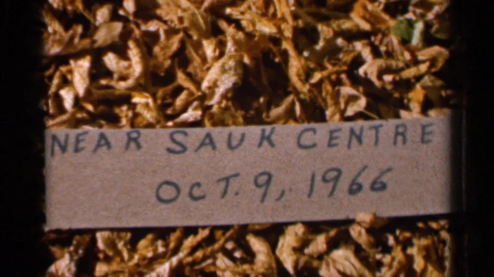 Close 8mm frame of the title card noting near Sauk Centre and Oct. 9, 1966, placed among dry leaves.