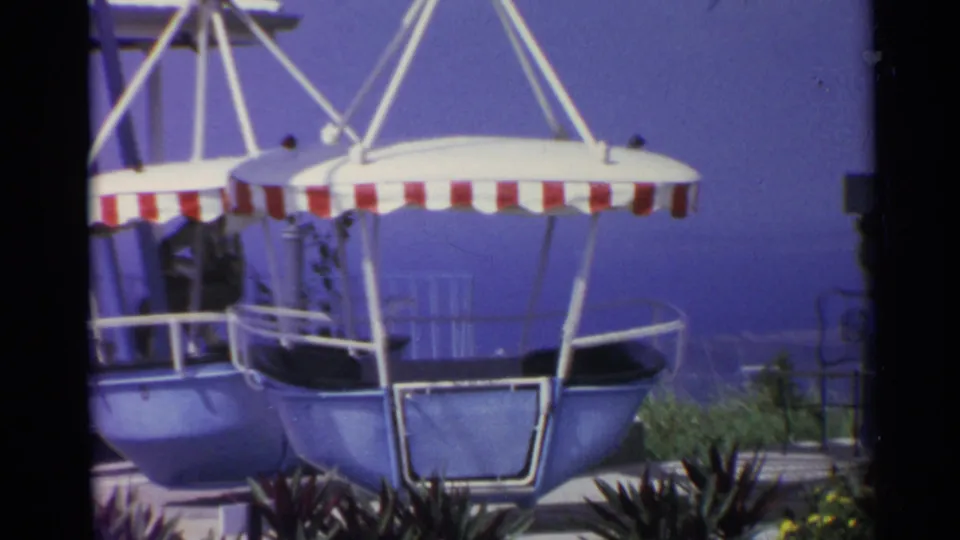 1967 US Virgin Islands frame showing empty seaside amusement-ride gondolas under red-and-white striped canopies.