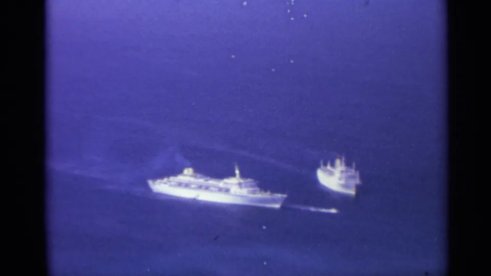 A larger passenger-style ship and a second vessel move across blue ocean in this 1967 US Virgin Islands home-movie frame.
