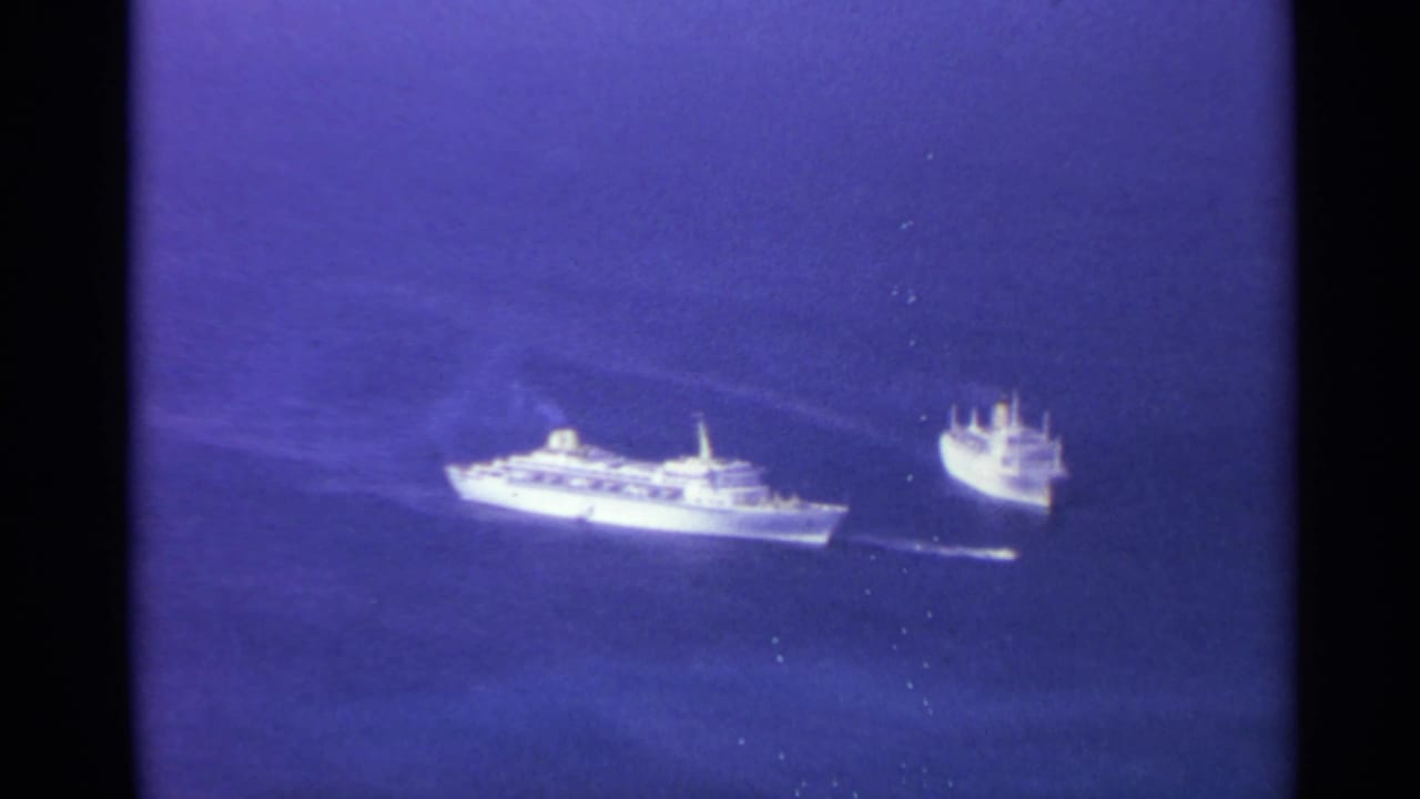 1967 8mm frame showing two distant white vessels moving across blue open water, likely near the US Virgin Islands.